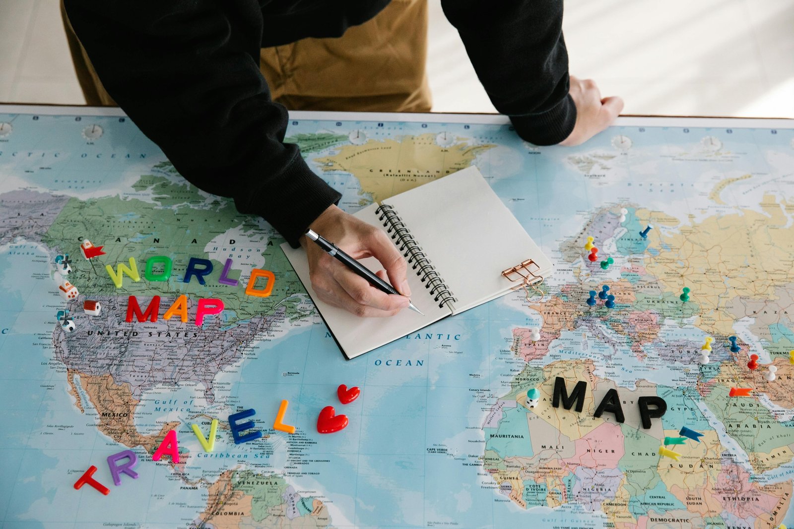 Travel planning notebook with laptop and map illustrating organized trip preparation
