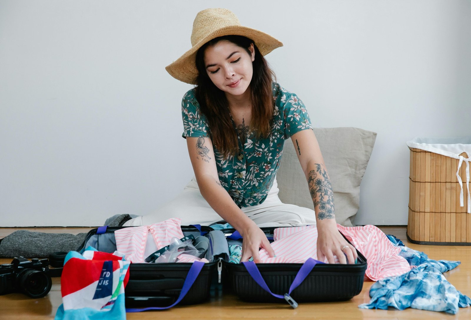 Woman packing travel essentials including clothes, personal care products, and safety tools for a safe and stylish trip