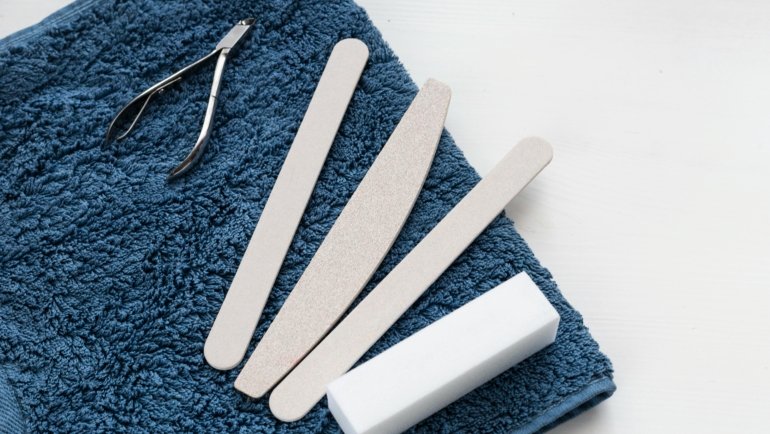 Compact nail care travel kit with stainless steel tools neatly organized beside travel essentials