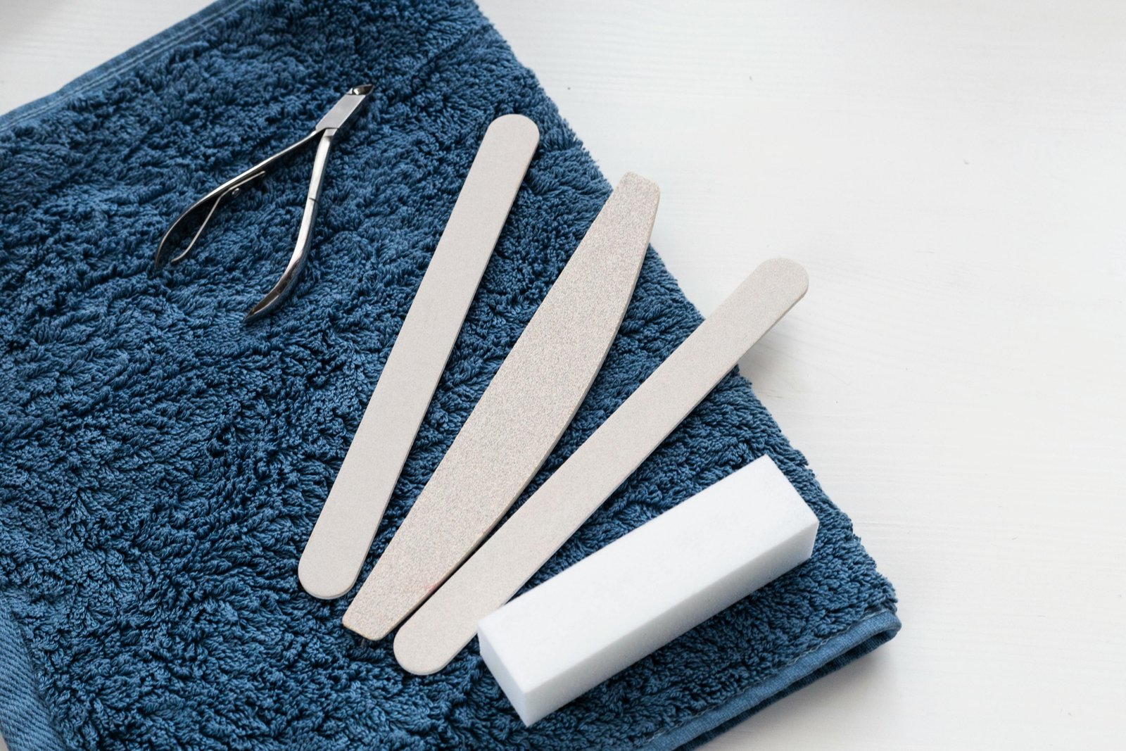 Compact nail care travel kit with stainless steel tools neatly organized beside travel essentials