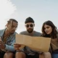 Happy travelers booking a vacation online with a laptop, planning a trip effortlessly