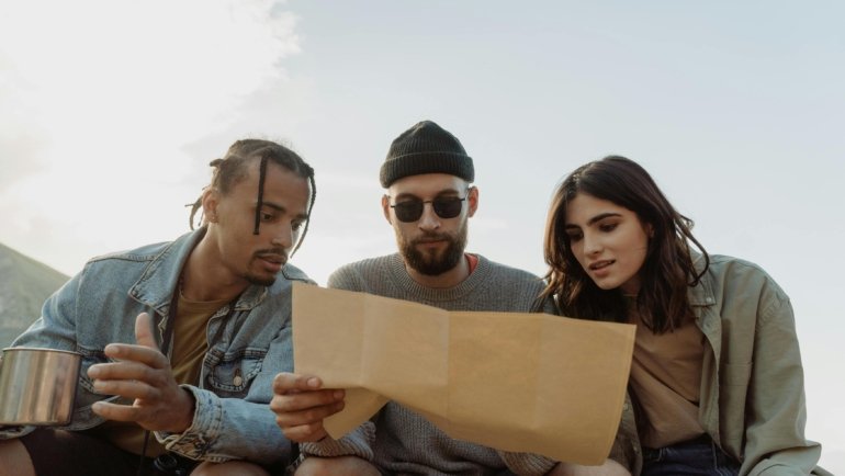 Happy travelers booking a vacation online with a laptop, planning a trip effortlessly