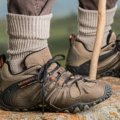 Comfortable travel shoes worn by a traveler walking outdoors on mixed terrain, showcasing style and durability for various travel activities
