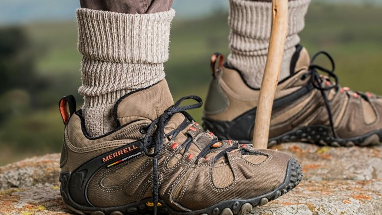 Comfortable travel shoes worn by a traveler walking outdoors on mixed terrain, showcasing style and durability for various travel activities