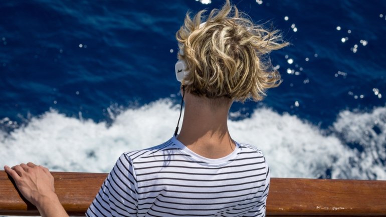 Person listening to music with headphones feeling inspired to travel and explore new destinations