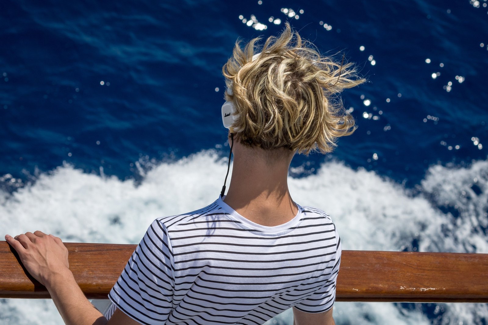 Person listening to music with headphones feeling inspired to travel and explore new destinations