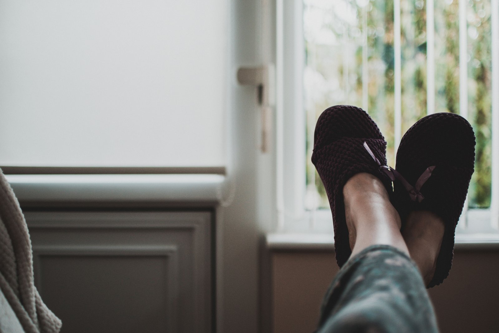 Woman wearing comfortable and stylish travel slippers relaxing in a hotel room during a trip