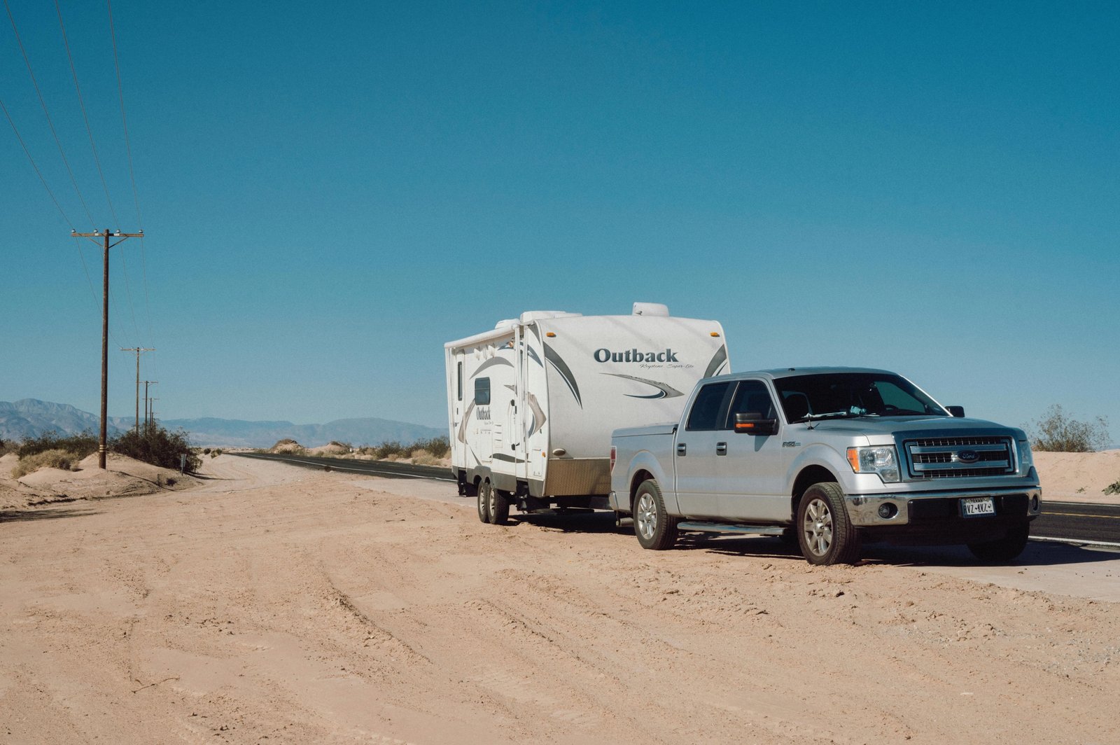 Grey Wolf Limited travel trailer parked in a forest campsite with sunlight and outdoor adventure setting