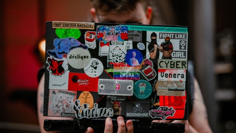 Colorful travel stickers decorating suitcase and laptop representing adventure and personalized travel gear