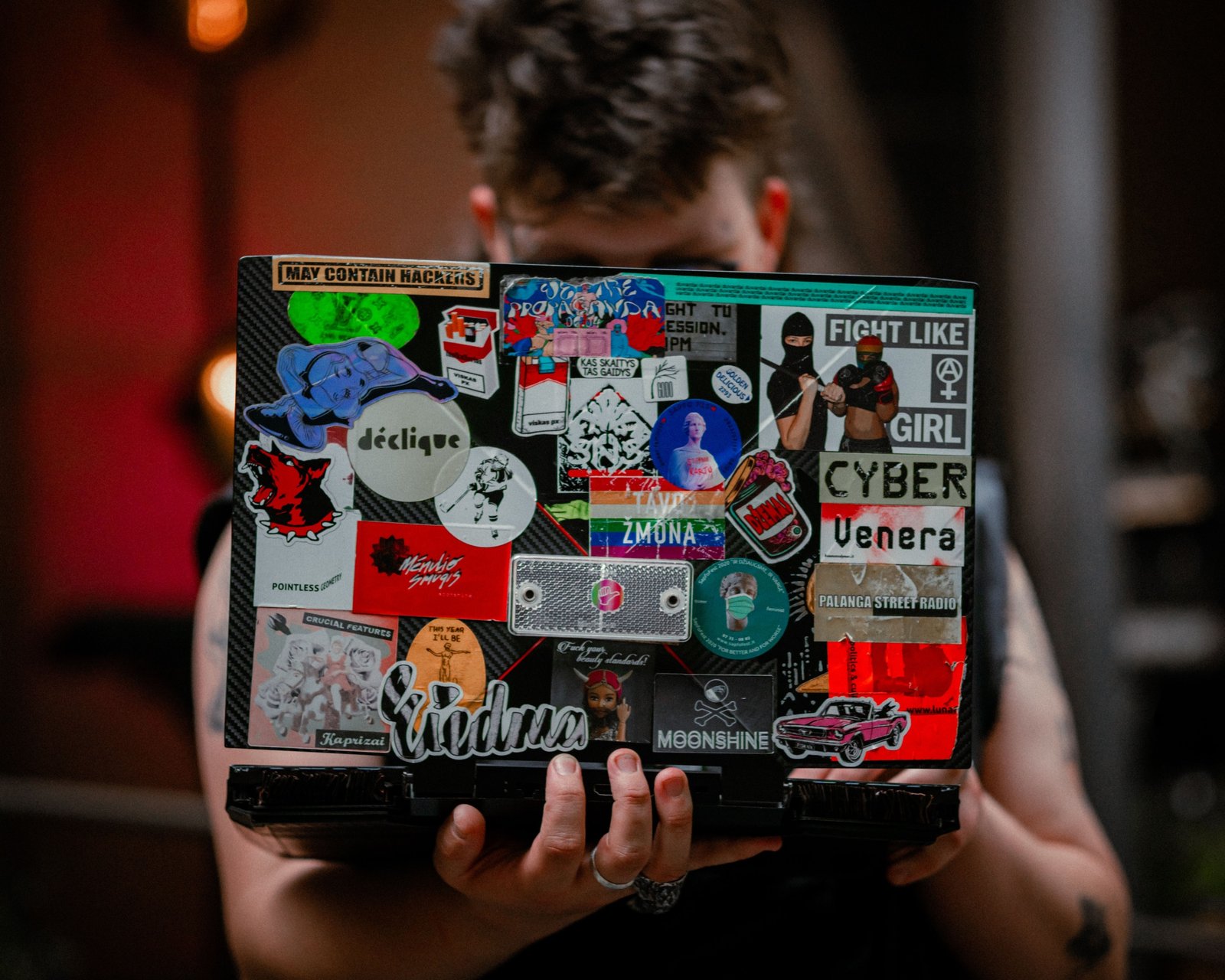 Colorful travel stickers decorating suitcase and laptop representing adventure and personalized travel gear