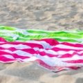 Lightweight colorful travel beach towel on sandy beach with ocean view, perfect for quick-dry and sand-resistant use
