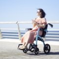 Lightweight foldable wheelchair for travel used by traveler in airport or outdoor setting, showcasing comfort and portability