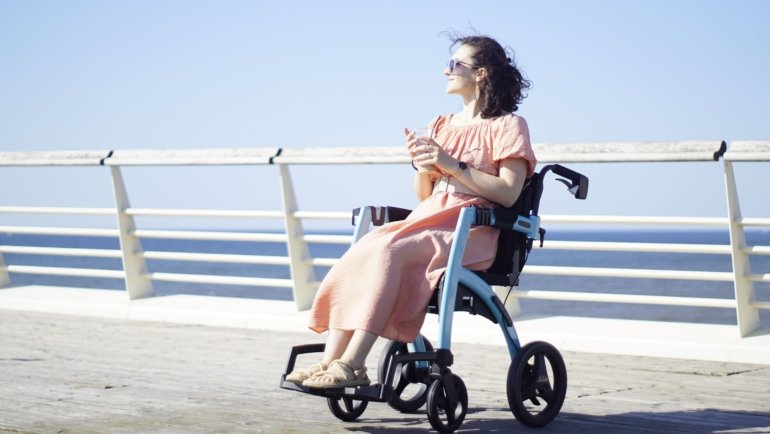 Lightweight foldable wheelchair for travel used by traveler in airport or outdoor setting, showcasing comfort and portability