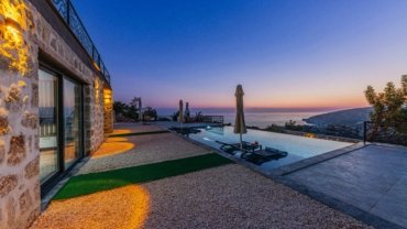 Luxury private villa at sunset with serene outdoor seating overlooking a pristine landscape, perfect for exclusive travel experiences