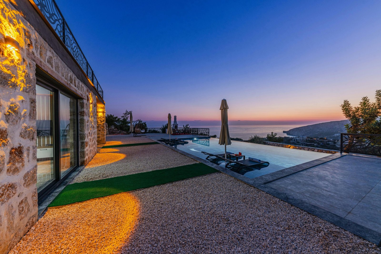 Luxury private villa at sunset with serene outdoor seating overlooking a pristine landscape, perfect for exclusive travel experiences