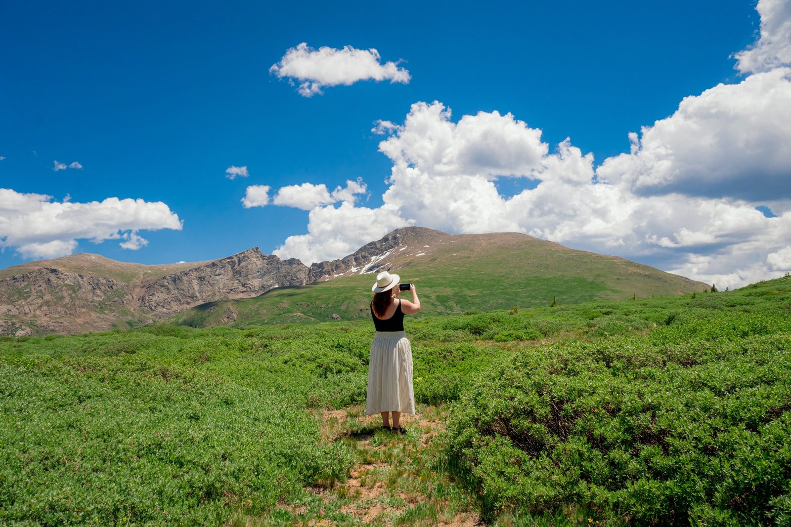 Travel nurse with medical gear in front of Colorado mountain landscape showcasing healthcare career and outdoor lifestyle