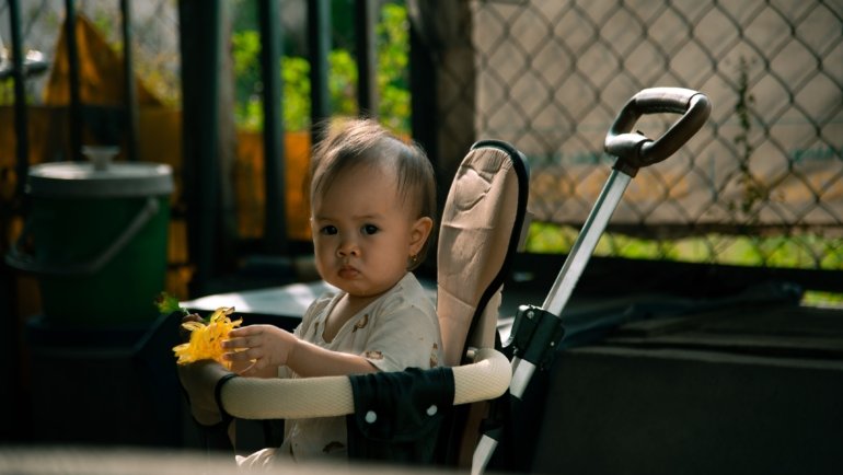 Safety 1st Smooth Ride Travel System moss green stroller with baby in outdoor environment showcasing safety and comfort