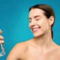Compact travel spritz bottle spraying a refreshing mist to hydrate skin during travel