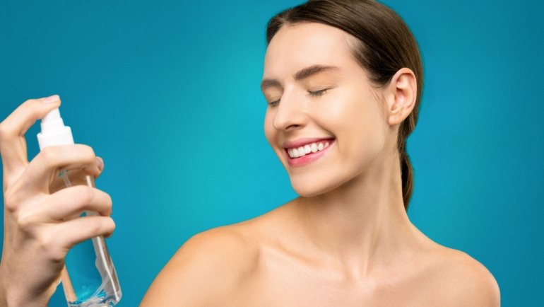Compact travel spritz bottle spraying a refreshing mist to hydrate skin during travel