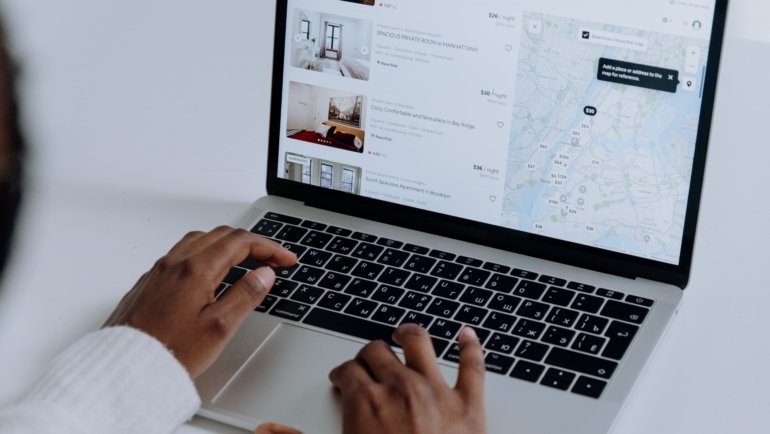 Person booking travel online using travel reservation booking technology for fast and efficient trip planning