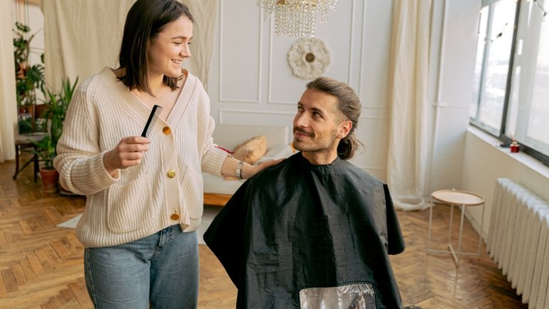 Traveling hairdresser giving a salon-quality haircut to a client at home, showcasing personalized mobile hairstyling service