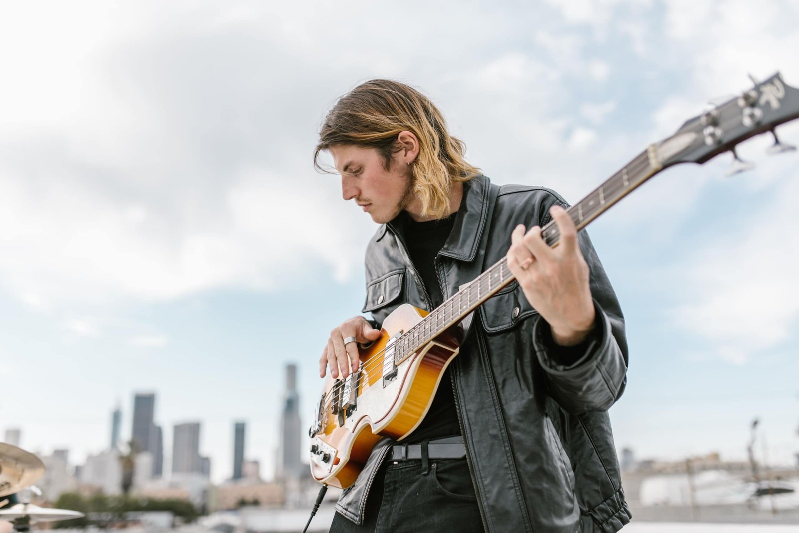 Lightweight travel electric bass guitar being played outdoors, highlighting portability and musical freedom for touring musicians