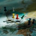 Colorful push pin travel map on wall with pins marking visited travel destinations
