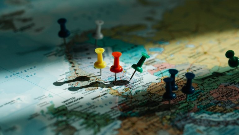 Colorful push pin travel map on wall with pins marking visited travel destinations