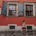 Stylish woman in comfortable dress walking on European street during travel