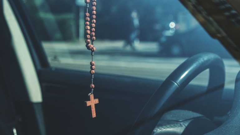 Catholic traveler praying for safety and protection before a journey