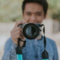 Traveler using a compact mirrorless camera to capture high-quality photos during a scenic outdoor adventure