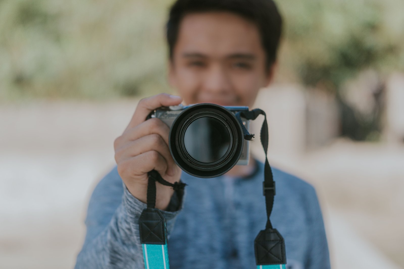 Traveler using a compact mirrorless camera to capture high-quality photos during a scenic outdoor adventure
