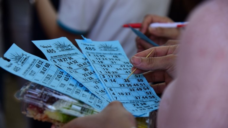 Group of happy travelers playing bingo on a cruise ship enjoying social travel entertainment