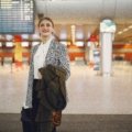 Business traveler checking in at airport with Dubai airport signage, illustrating smooth USA to Dubai international travel experience
