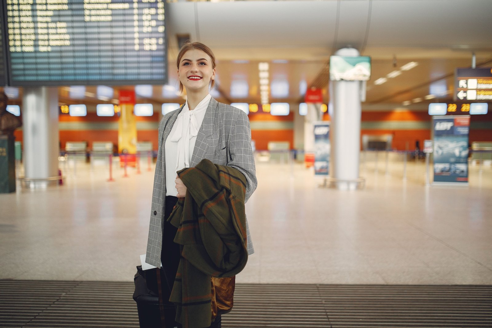 Business traveler checking in at airport with Dubai airport signage, illustrating smooth USA to Dubai international travel experience