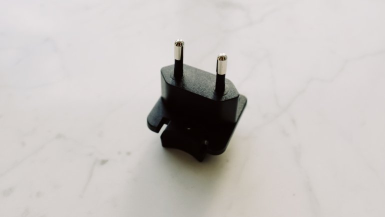Travel adapter plugged into Brazil Type N electrical outlet ensuring safe device charging during Brazil trip