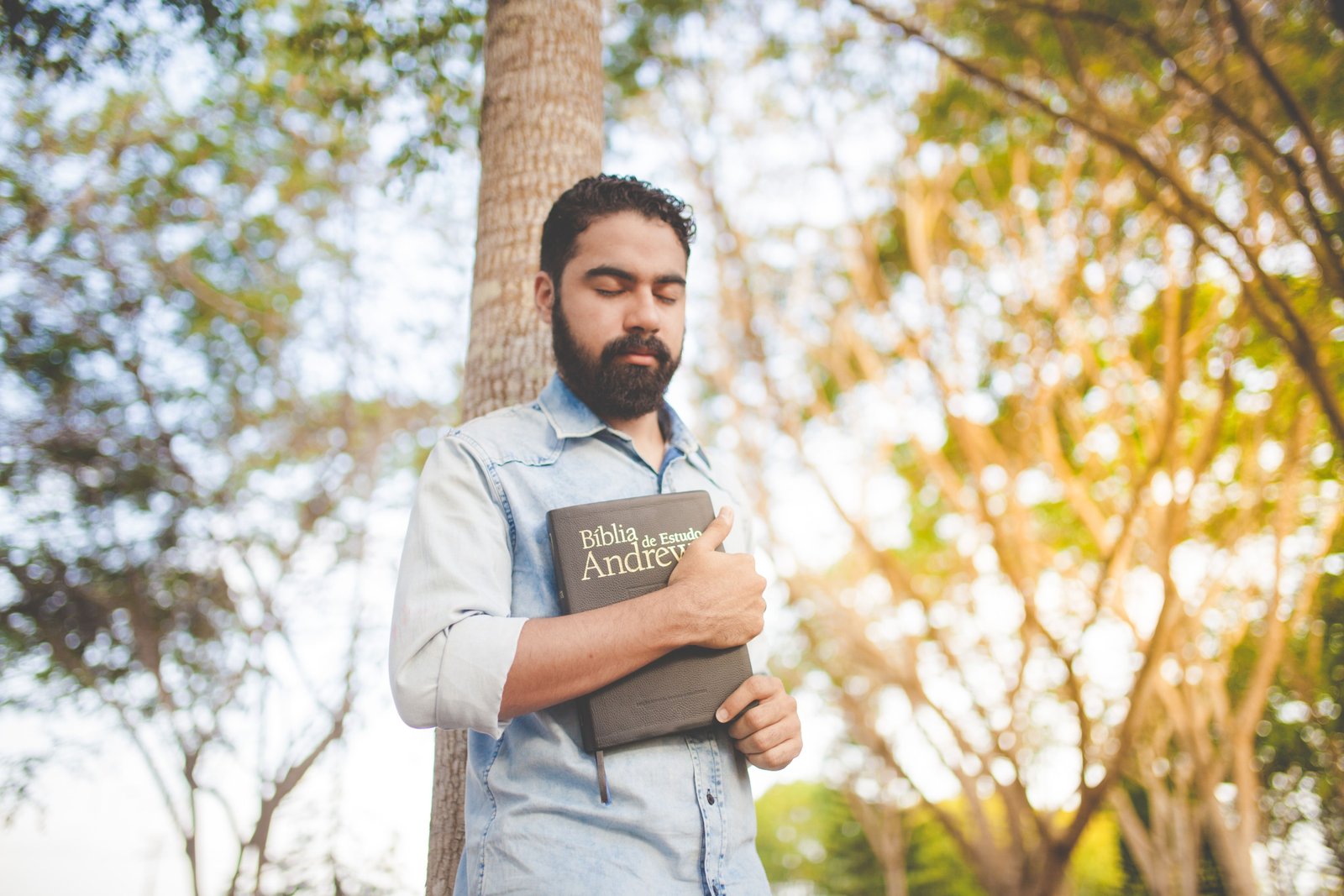 Traveler holding a Bible outdoors symbolizing spiritual protection and peace during travel