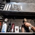 Close-up of a professional barber travel case with organized grooming tools including clippers, scissors, and combs