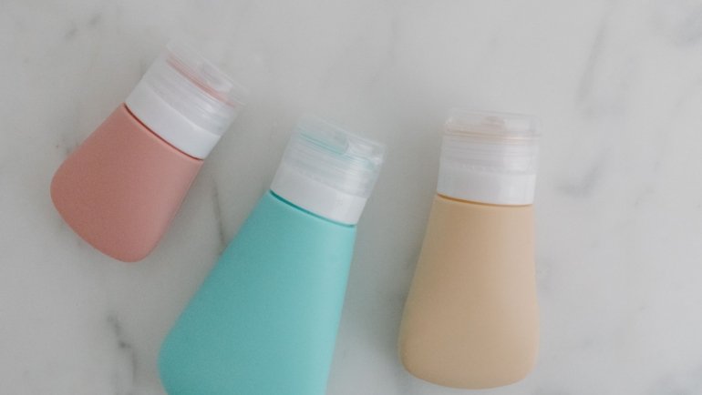 Travel toiletry bag filled with multiple travel size body wash bottles for convenient and space-saving packing