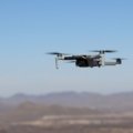 Compact travel drone flying over scenic landscape capturing aerial photos and videos for travelers