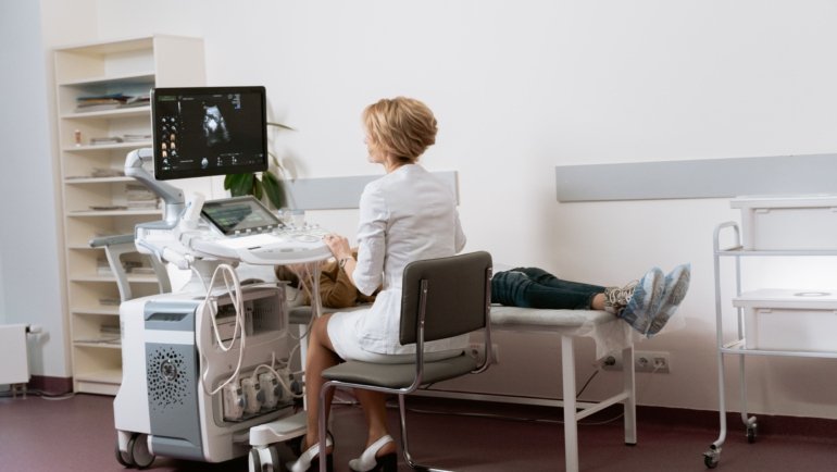 Cardiac sonographer performing echocardiogram in hospital, showcasing healthcare travel job experience