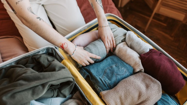 Close-up of clothes packed neatly in a suitcase, illustrating the potential for bed bugs to travel on clothing during travel