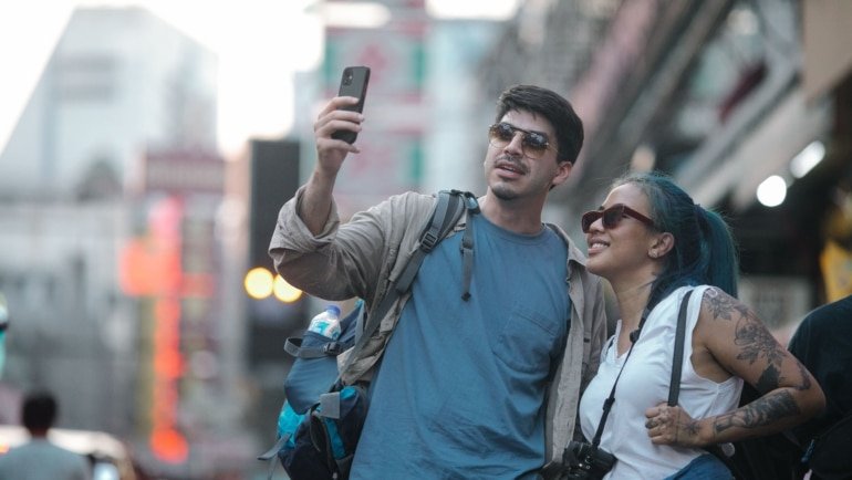Traveler confidently using smartphone abroad with travel insurance assistance for safety and emergency support