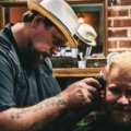 Man getting a fresh haircut in a barbershop while traveling, combining grooming and adventure