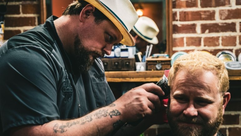 Man getting a fresh haircut in a barbershop while traveling, combining grooming and adventure