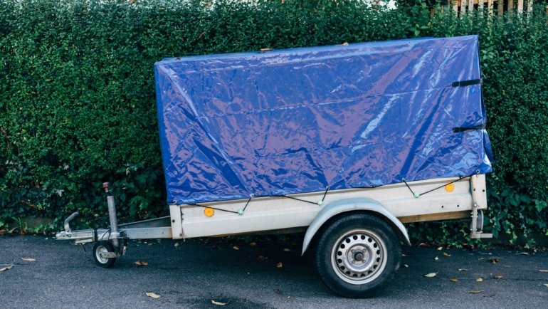 Travel trailer tire protected by a heavy-duty UV-resistant tire cover for outdoor storage and durability