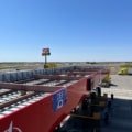 Lamar Travel Plaza highway rest stop with fuel station, parking, and travelers resting during a road trip