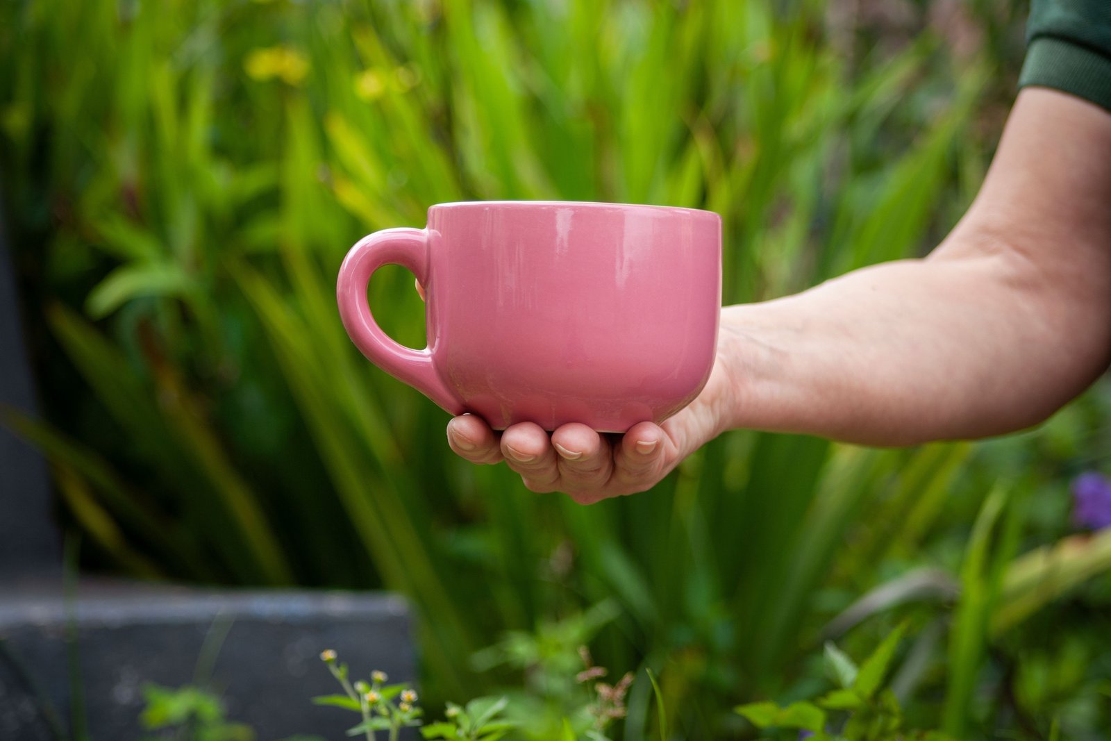 Pink stainless steel travel coffee mug outdoors, reusable and leak-proof with bright color, perfect for commuting and travel