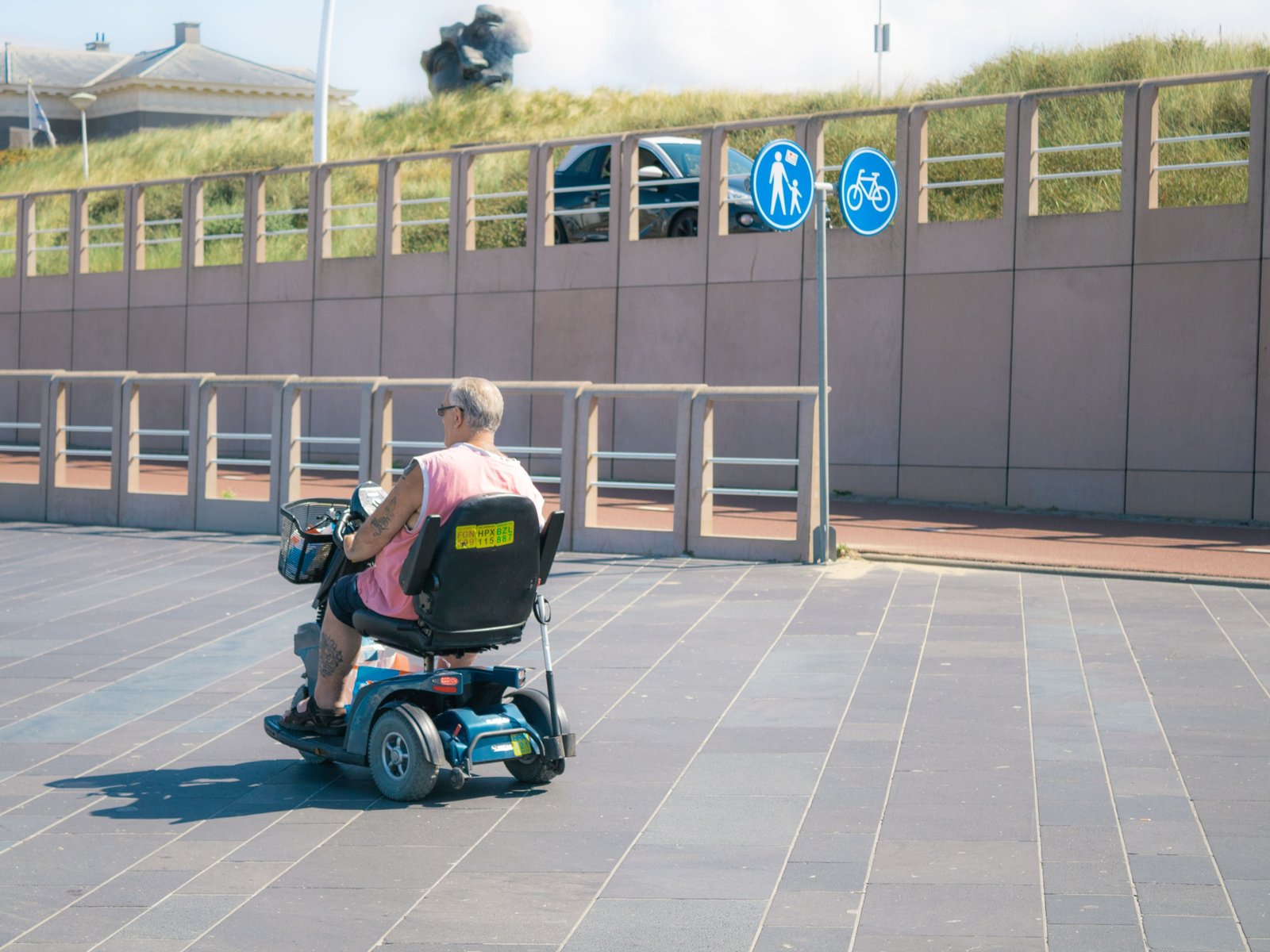 Lightweight portable travel disability scooter used by a traveler outdoors for easy and independent mobility
