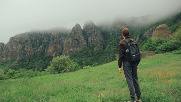 Brave outdoor traveler hiking confidently in nature with proper gear, symbolizing courage and preparedness for safe adventure